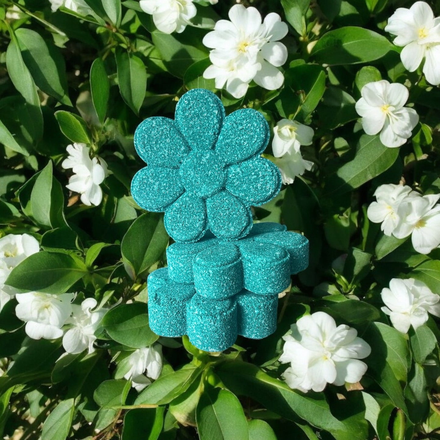 A handmade teal coloured flower shaped Jasmine scented bath bomb