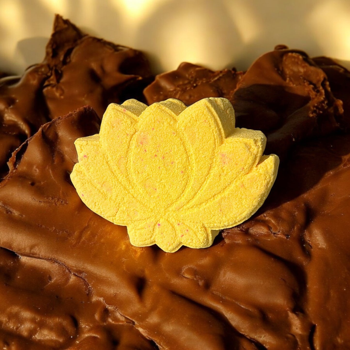 A handmade yellow coloured lotus flower shaped Biscoff scented bath bomb