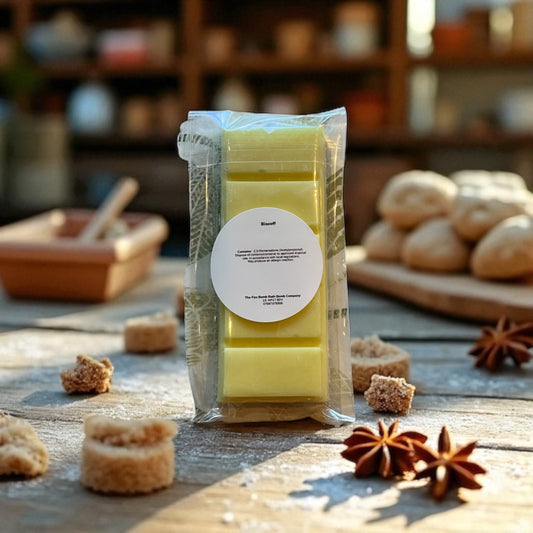 Packaged yellow wax melts on a wooden surface with star anise and other items.