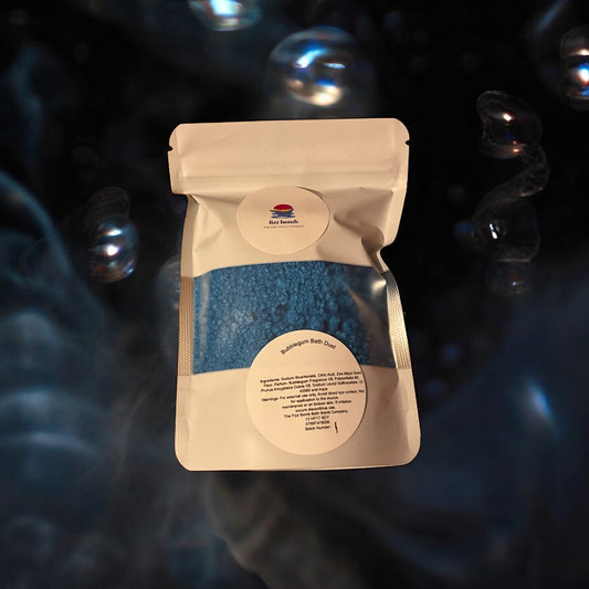 Beige packaging of blue bath dust with a label on a dark background