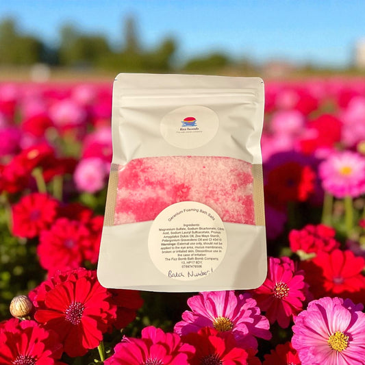 Geranium Scented foaming Bath salts in a bag with a geranium flowers background