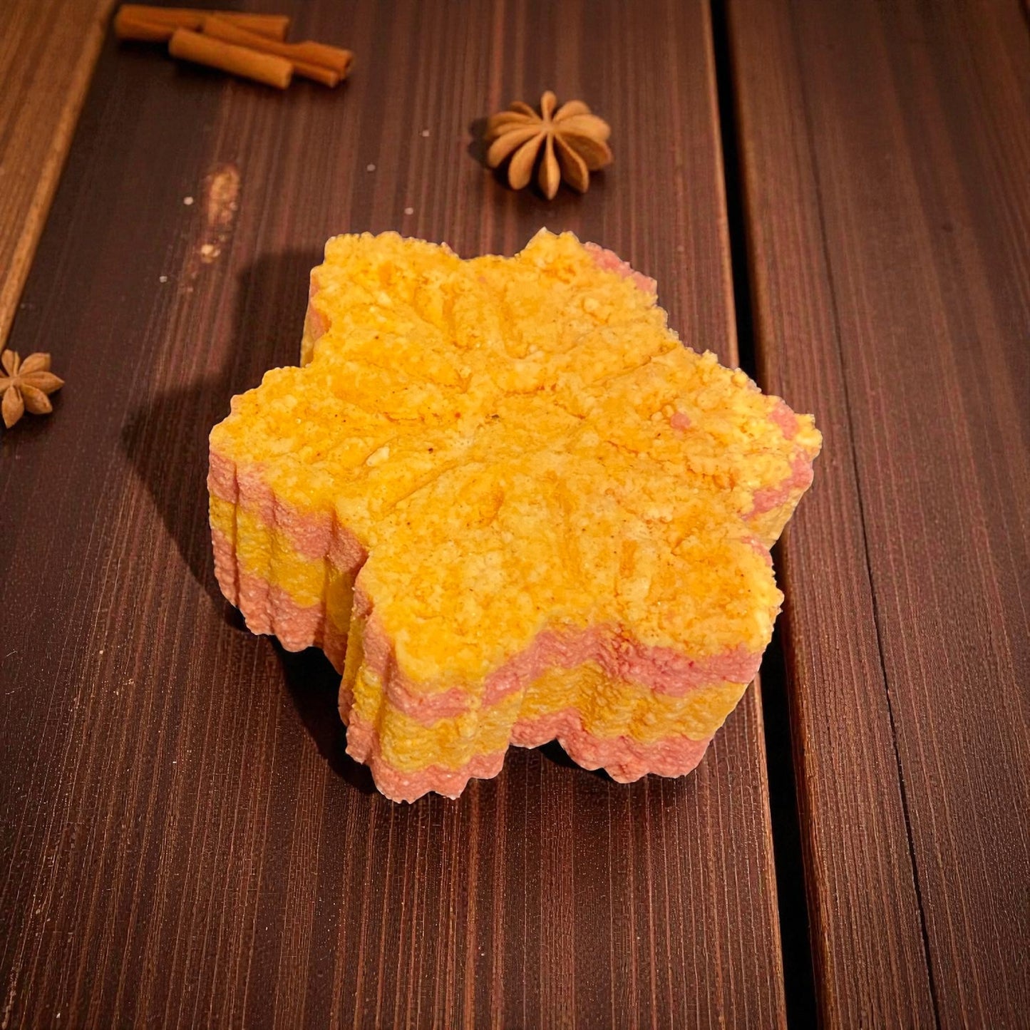 Snowflake shaped red and orange bath bomb with a ginger themed background
