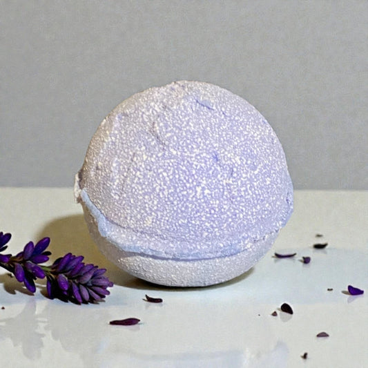 Violet coloured bath bomb with lavender flowers on a light gray background