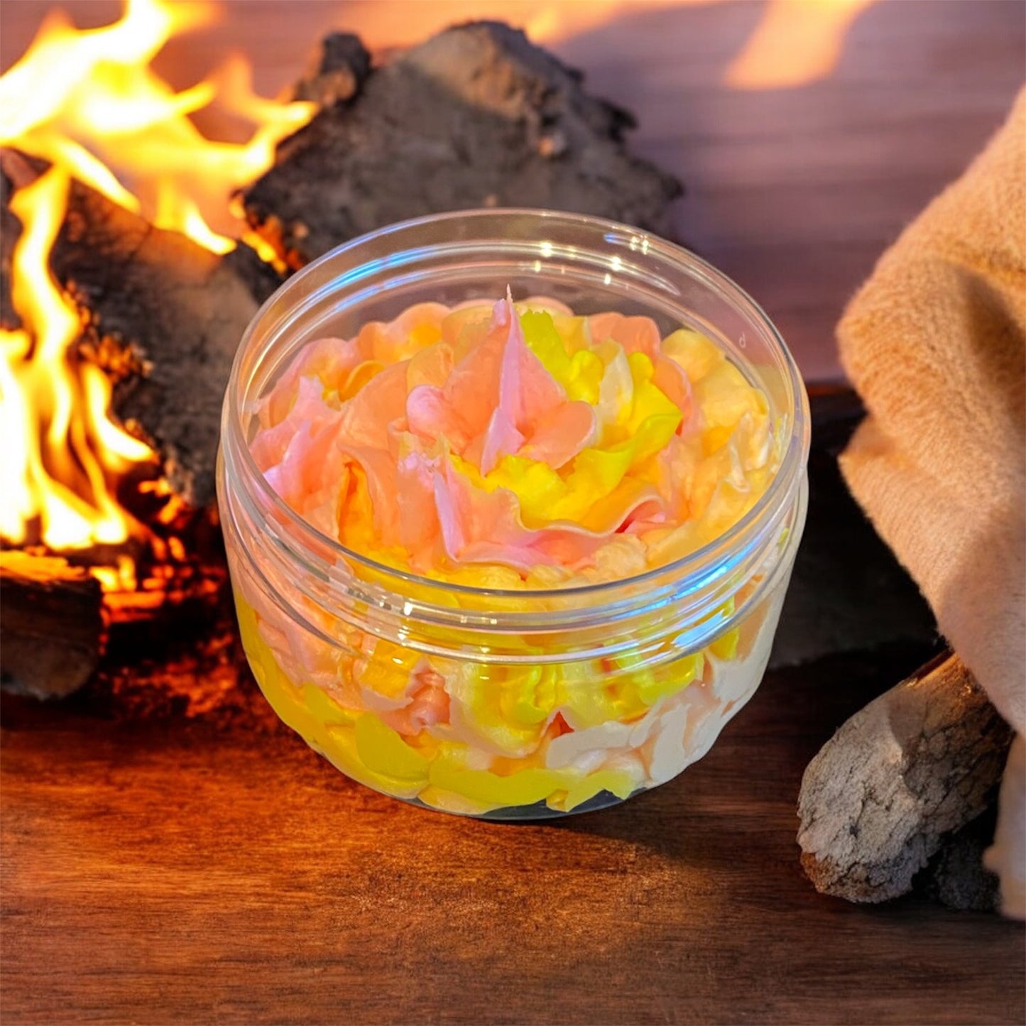 A red orange and yellow piped whipped soap in a plastic jar