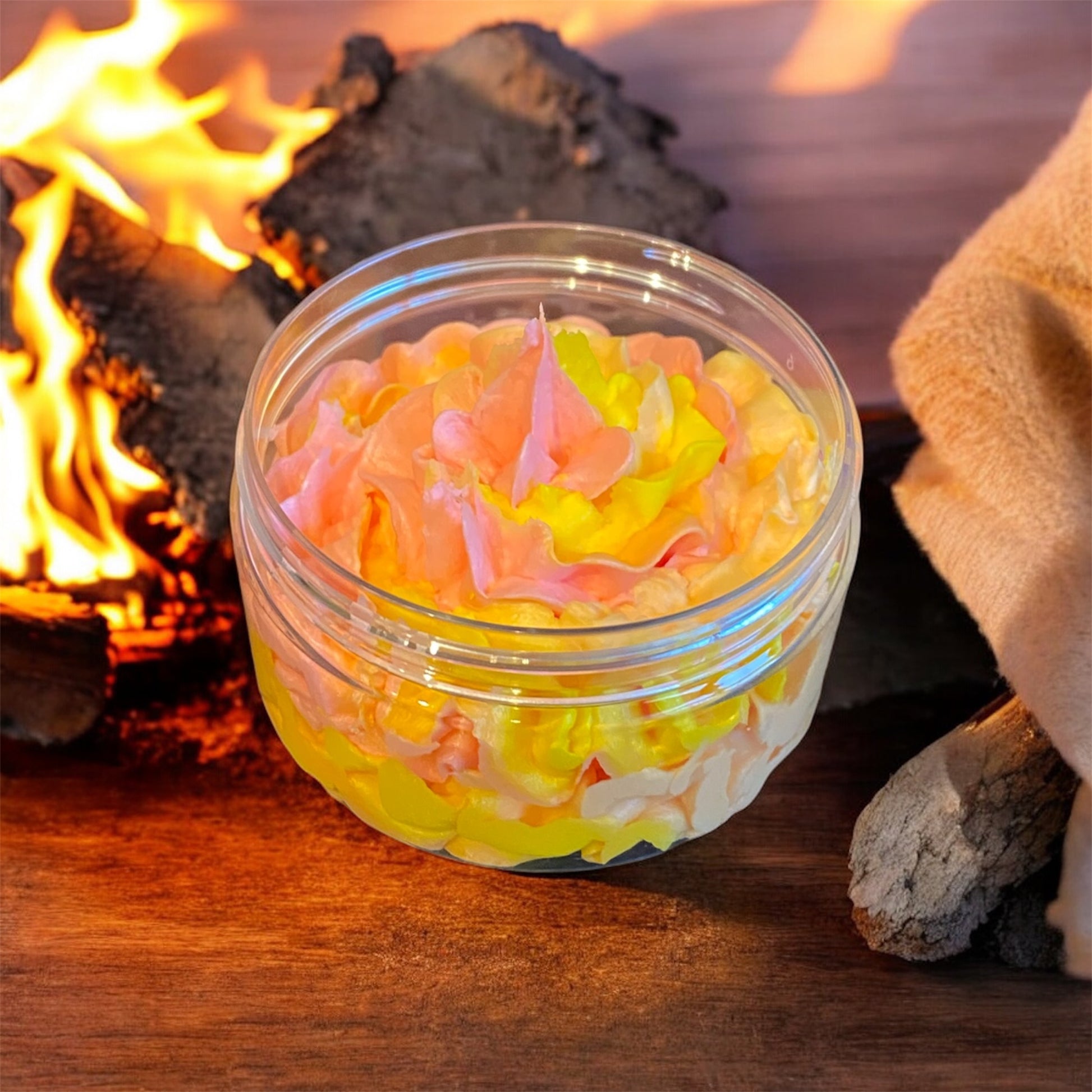 A red orange and yellow piped whipped soap in a plastic jar
