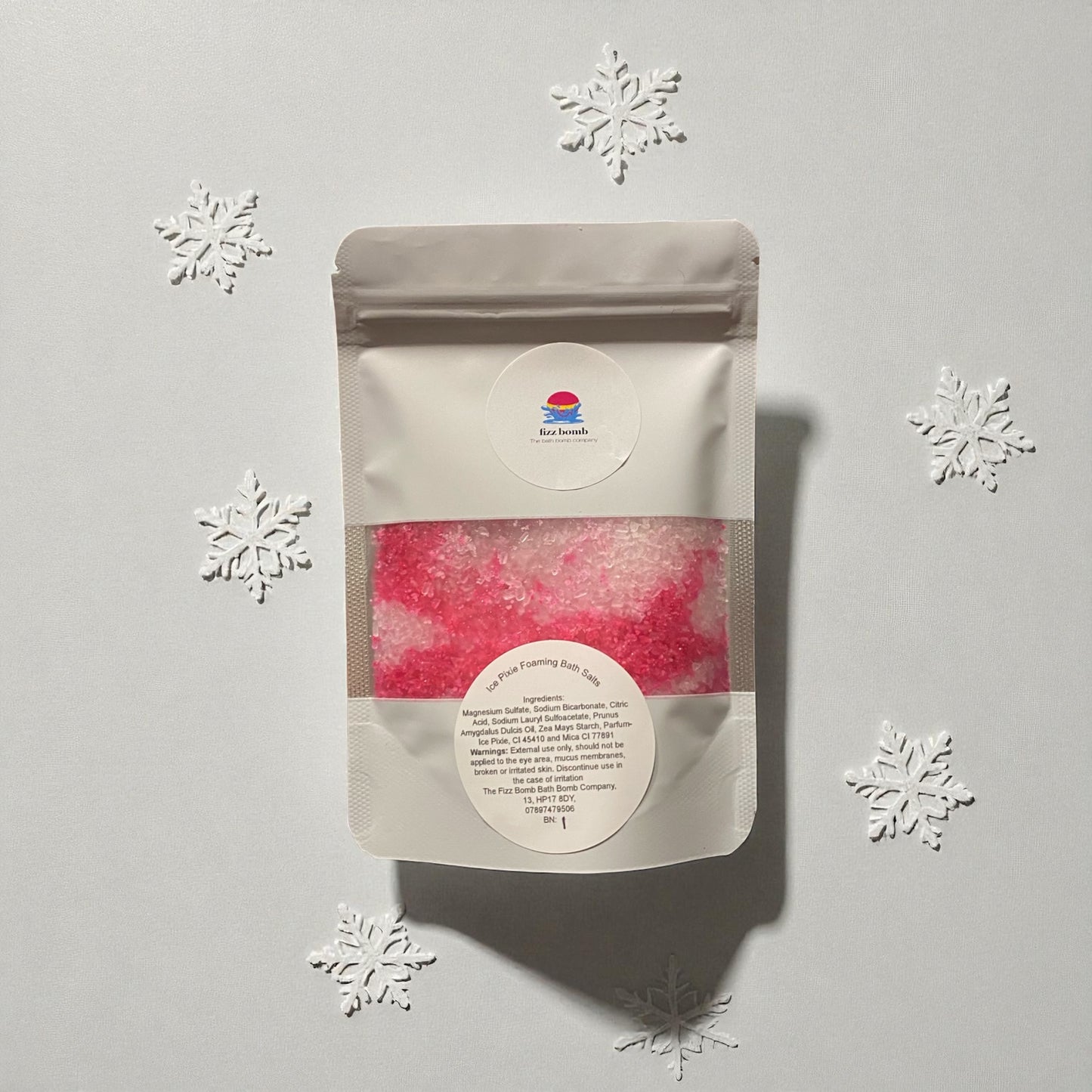 Packaged product with a label on a light gray background with snowflake decorations