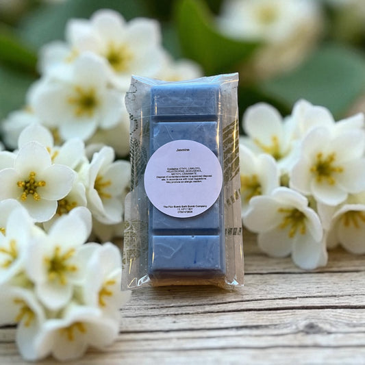 A blue coloured Jasmine wax melt with a jasmine flowers background.