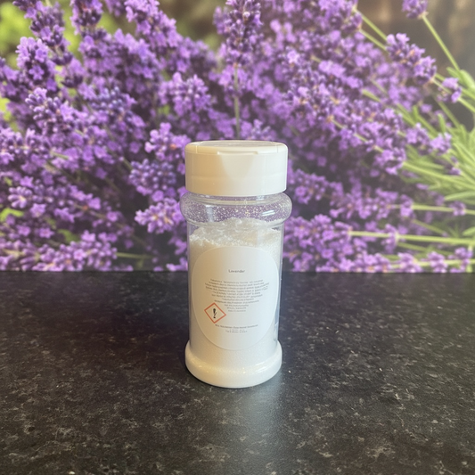 A shaker bottle of carpet freshener with lavender flowers background 