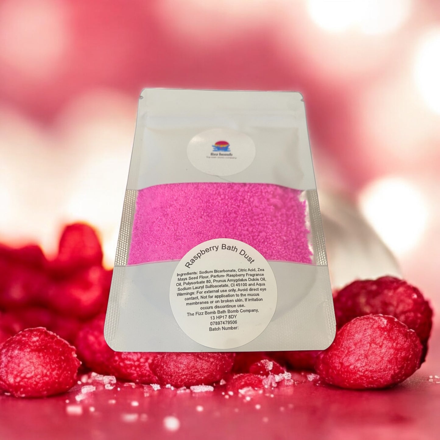 A bag of handmade hot pink raspberry Bath dust with a raspberries background