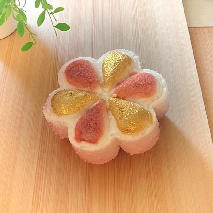 A rhubarb and custard scented handmade gold and pink painted shower steamer