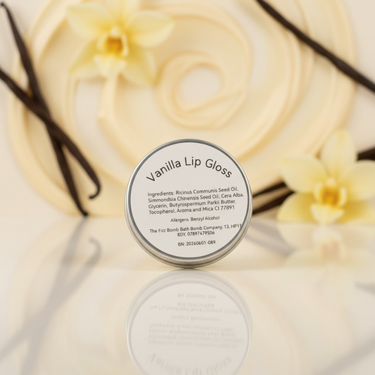 Vanilla lip gloss container with vanilla flowers and vanilla beans in the background